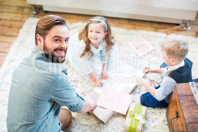 Father and kids packing gifts