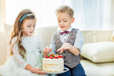Siblings holding cake