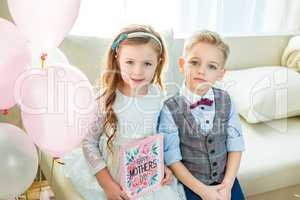 Siblings holding Mothers Day card