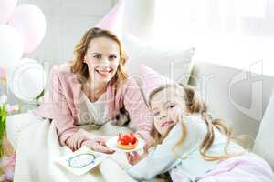 Mother and daughter with strawberry cake