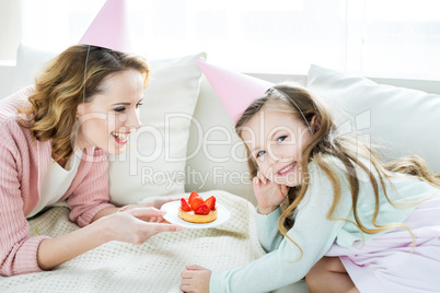 Mother and daughter with strawberry cake