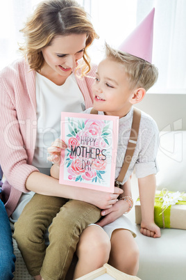 Mother and son holding greeting card