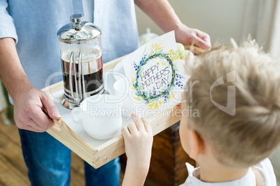 Father and son holding tray with card