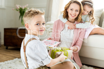 Boy presenting gift to mother