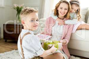 Boy presenting gift to mother