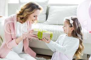 Girl presenting gift to mother