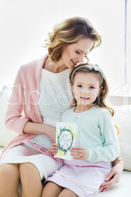 Beautiful mother and daughter with cards