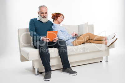 Couple using laptop and digital tablet