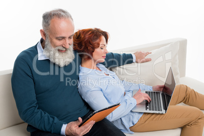 Couple using laptop and digital tablet
