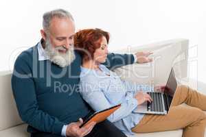 Couple using laptop and digital tablet