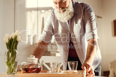 Man holding tray with tea