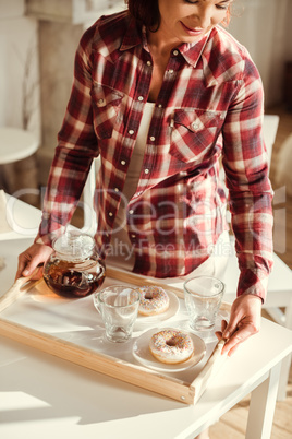 Woman holding tray with tea