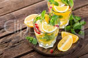 Lemon mojito cocktail with mint and pomegranate, cold refreshing drink or beverage
