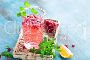 Infused pomegranate water with fresh lemon and ice, cold healthy refreshing and detox drink