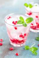 Infused water made of fresh pomegranate and mineral water with ice, cold refreshing and detox drink