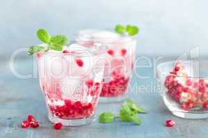 Infused water made of fresh pomegranate and mineral water with ice, cold refreshing and detox drink