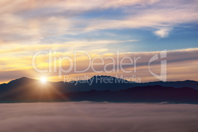 Bright sunrise, the mist in a mountain valley and mountain peaks