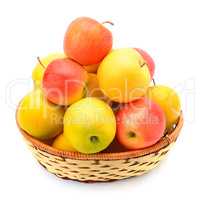 red and yellow apples in a wicker basket isolated on white backg