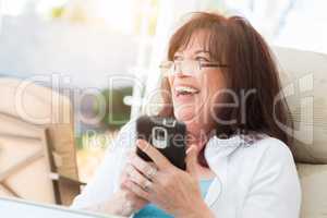 Attractive Middle Aged Woman Laughing While Using Her Smart Phon