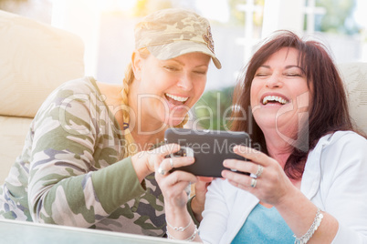 Two Female Friends Laugh While Using A Smart Phone