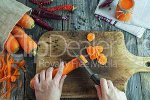process of cutting slices of fresh carrots on a chopping board