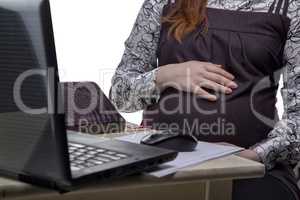 Pregnant woman hugging belly at work