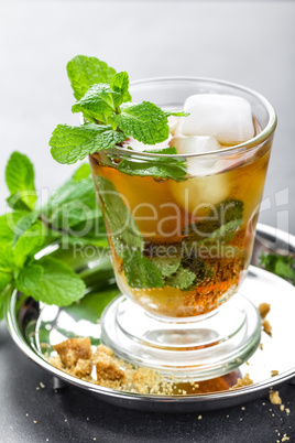 Mint Julep cocktail with bourbon, ice and mint in glass on black background