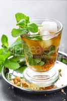 Mint Julep cocktail with bourbon, ice and mint in glass on black background