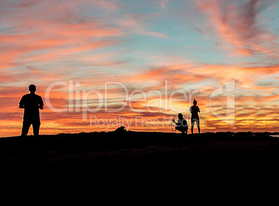 Silhouette of people enjoying the beach at sunset