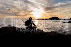 Silhouette of Fisherman holding a fishing pole