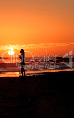 Silhouette of young woman enjoying the beach