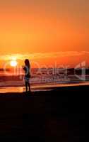 Silhouette of young woman enjoying the beach