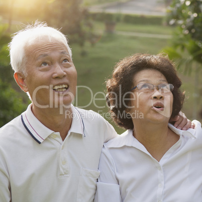 Asian seniors couple looking up