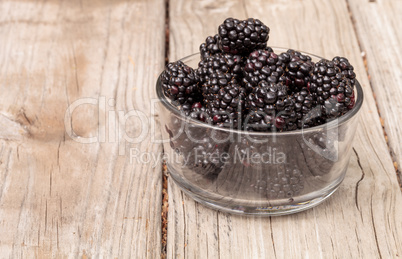 Clear glass bowl of ripe blackberries