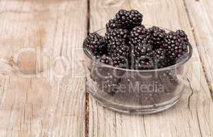 Clear glass bowl of ripe blackberries