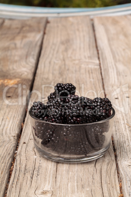 Clear glass bowl of ripe blackberries