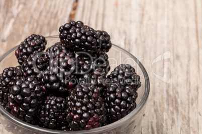 Clear glass bowl of ripe blackberries