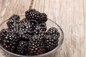 Clear glass bowl of ripe blackberries