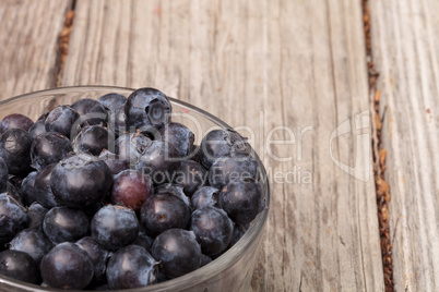 Clear glass bowl of ripe blueberries