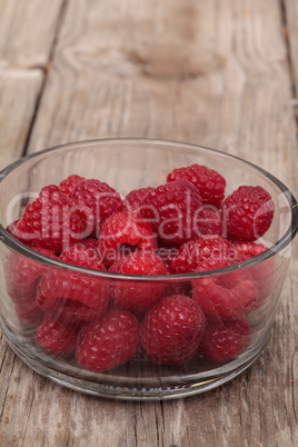 Clear glass bowl of ripe raspberries