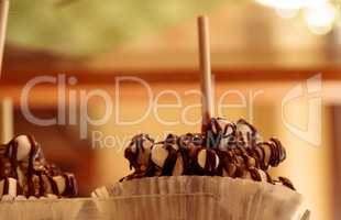 Candy apples with caramel and nuts on a stick in a candy store w