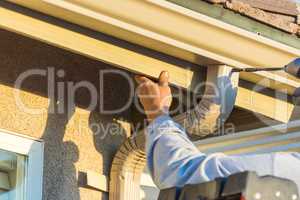 Worker Attaching Aluminum Rain Gutter and Down Spout to Fascia o