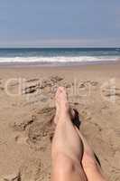 Feet and legs crossed in sand