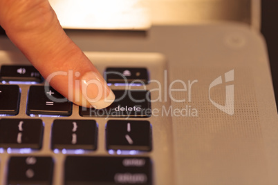 Female finger on the delete key