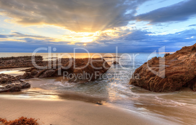 Sunset over the rocks at Pearl Street Beach