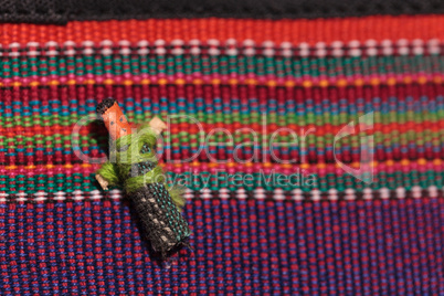 Macro of a handmade little textured Mexican cloth doll