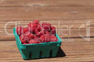 Organic red raspberries in a green basket