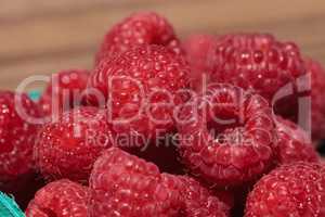 Organic red raspberries in a green basket