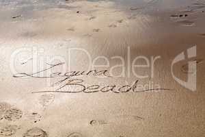 Laguna Beach written in script the wet sand