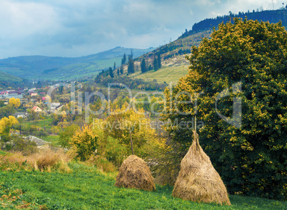 Autumn mountain view with stacks of hay